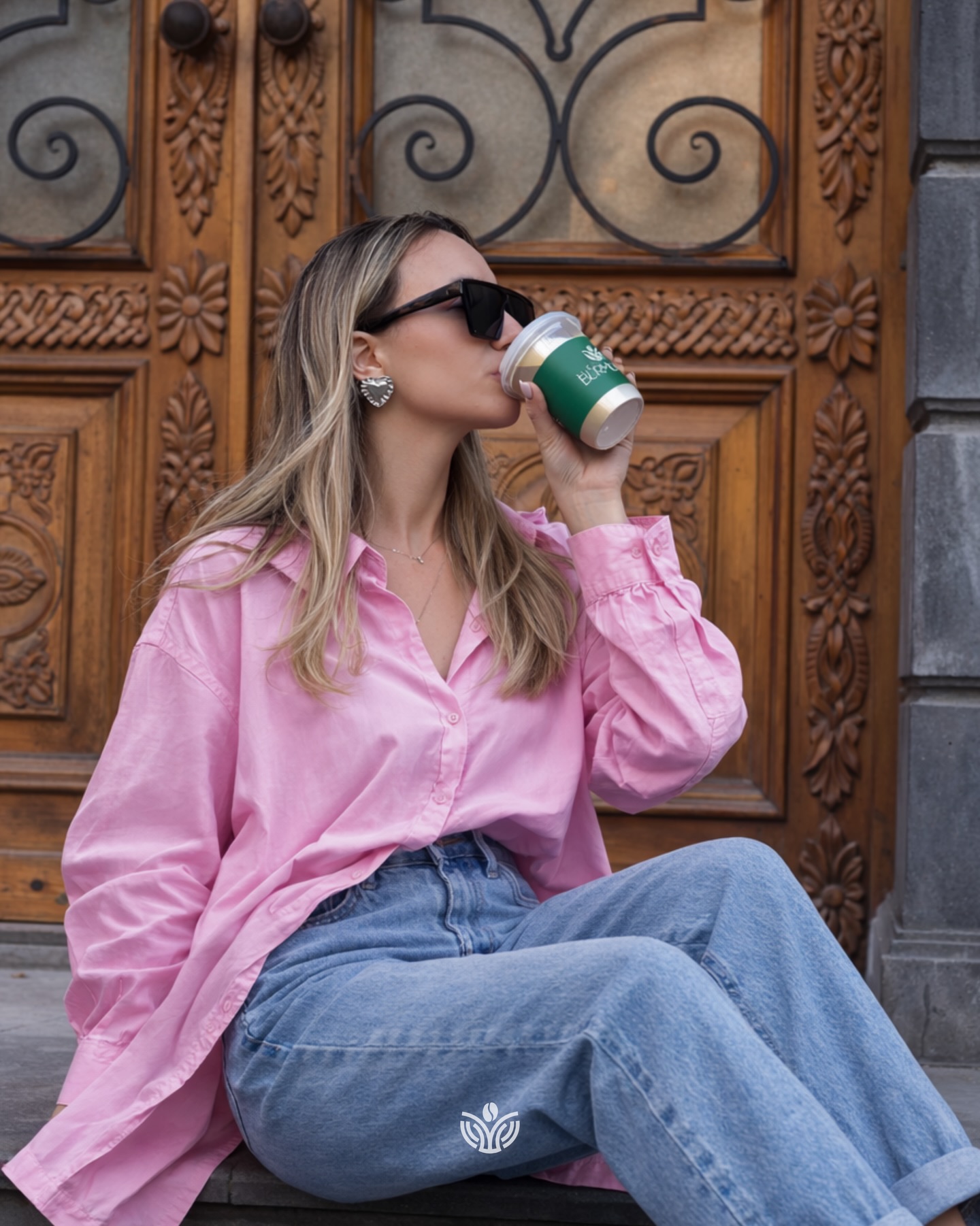 Женщина пьет Coffee Burmunq из стакана навынос
